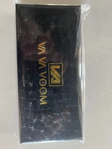 Detalle de caja de regalo rectangular negra con textura de cocodrilo y logotipo dorado
