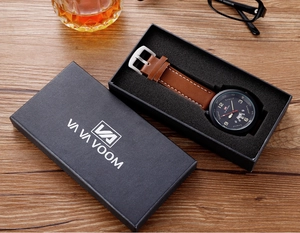 Detalle de la caja de regalo rectangular negra con logo dorado para reloj de lujo