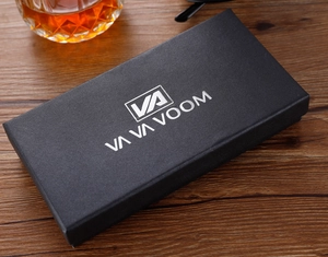 Caja de reloj rectangular negra textura cocodrilo con logo plateado sobre madera