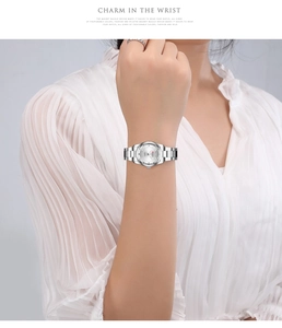 Silver quartz watch with mesh strap and magnetic buckle on female wrist for business fashion