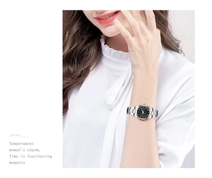 Close-up of elegant women's watch with black dial and silver stainless steel strap on wrist