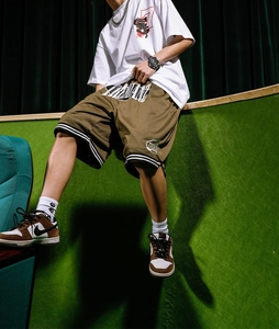 Detail view of men's casual white t-shirt and mesh shorts with street style graphics