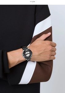 Dettaglio di un orologio da uomo in acciaio nero con design traforato su un polso maschile