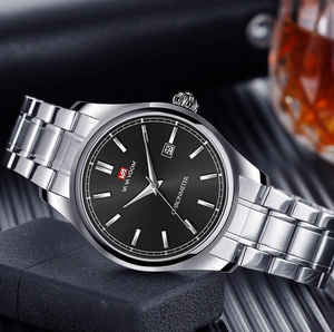 Détail d'une montre en acier avec cadran noir et affichage du calendrier dans un cadre chic