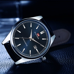 Gros plan du cadran bleu marine avec guichet de date et index argentés sur montre homme