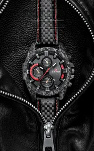 Détail macro de la montre de sport chronographe avec texture carbone et touches rouges