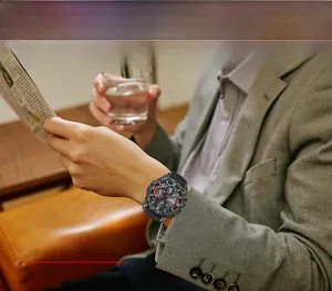 Gros plan d'un chronographe militaire en fibre de carbone au poignet d'un homme en situation