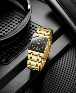 Close-up of gold square business watch showing the black dial with Roman numerals and calendar