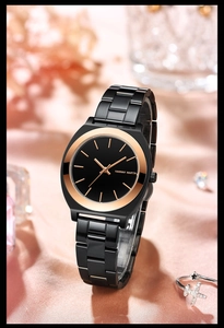 Detail view of the black and rose gold women's watch resting on pink silk fabric