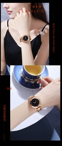 Rose gold quartz watch with black dial and metal strap shown in a lifestyle setting