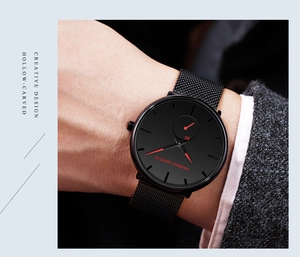 Close-up of minimalist black mesh strap watch with red hands worn on a wrist