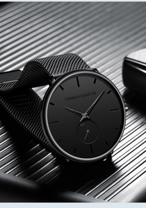 Macro shot of the black matte metal watch dial and Milanese stainless steel strap details
