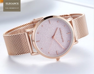 Gros plan du bracelet en maille rose doré et du cadran pailleté rose de la montre