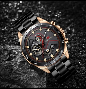 Detail of rose gold and black quartz chronograph watch on a textured stone surface