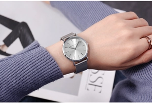 Close-up of Hannah Martin silver watch with Milanese mesh strap on woman's wrist