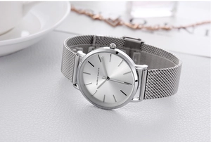 Detailed macro shot of the silver Milanese mesh strap and sunburst dial on the watch
