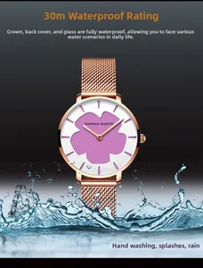 Détail du cadran de montre étanche avec fleur violette et bracelet en maille d'or rose dans l'eau