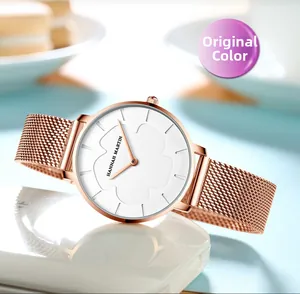 Gros plan sur la montre en maille or rose avec motif floral en relief sur cadran blanc