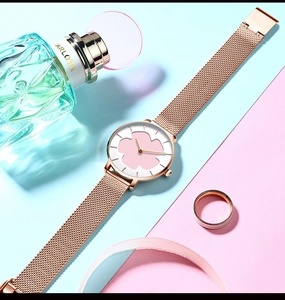 Gros plan du bracelet milanais en or rose et cadran avec motif floral rose
