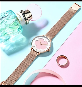 Détail du bracelet en maille or rose et cadran blanc avec motif de fleurs roses sur montre