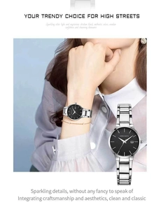 Detailed view of women's stainless steel watch featuring a black dial and silver metal link band