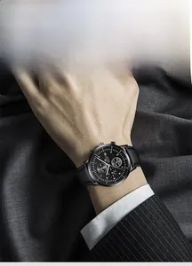 Detail of a men's business chronograph watch with black leather strap and multi-function dial