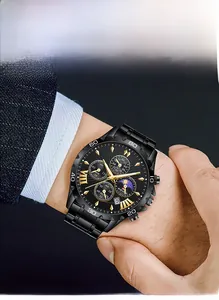 Gros plan d'une montre chronographe noire pour homme avec détails dorés portée au poignet