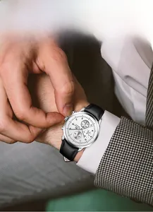 Detail of silver chronograph men's business watch with black leather strap and white dial