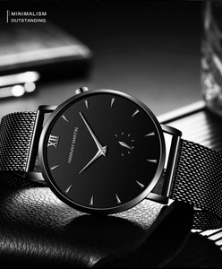 Detailed close-up of a minimalist black business watch with stainless steel mesh band