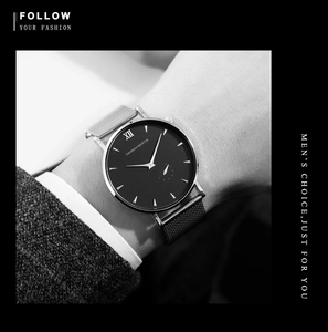 Detail of Hannah Martin business watch with silver mesh strap and black dial on a suit sleeve