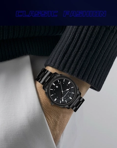 Gros plan d'une montre d'affaires en acier noir avec guichet date au poignet