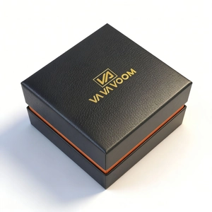 Detail of premium black lychee leather watch box with orange lining and golden logo