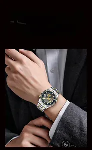 Close-up of a men's skeleton watch with a blue dial and two-tone steel band on a wrist
