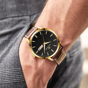 Nahaufnahme der Luxusuhr mit goldenem Gehäuse, Doppeldatum und braunem Lederarmband