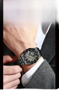 Detail of a black skeleton mechanical watch with stainless steel band on a business suit