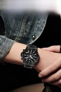 Macro shot of a black stainless steel multi-functional sports watch on a male model's wrist