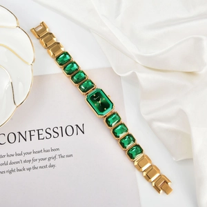 Elegante orologio a bracciale dorato con quadrante verde e pietre taglio smeraldo
