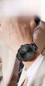 Gros plan d'une montre à quartz carrée noire avec cadran soleil et date au poignet