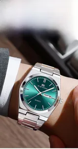 Détail d'une montre en acier argenté avec cadran vert soleil et affichage date
