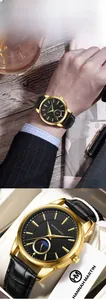 Makroansicht des schwarzen Zifferblatts mit goldenen Indizes und Mondphase an der Uhr