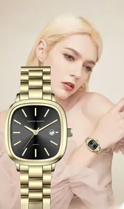 Close-up of women's gold square watch with black dial on wrist showing date window