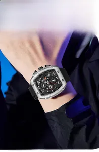 Men's tonneau steel watch with black silicone strap and three-eye dial on wrist