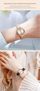 Detail einer quadratischen roségoldenen Uhr mit Lederarmbändern in Beige und Schwarz