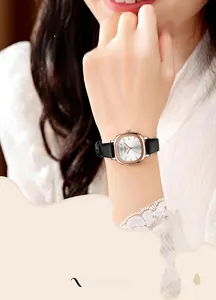 Nahaufnahme der quadratischen roségoldenen Uhr mit weißem Zifferblatt und Lederarmband