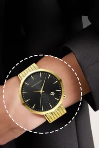 Detail of Hannah Martin gold mens watch with octagonal case and black dial on wrist