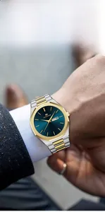 Detail of the men's stainless steel watch with blue dial and gold bezel under a suit sleeve