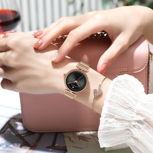 Elegant rose gold women's watch with black dial and swan bracelet on a pink background