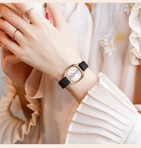 Nahaufnahme einer quadratischen Damenuhr in Roségold mit schwarzem Lederarmband am Handgelenk