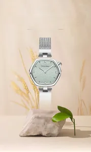 Detail view of ultra-thin hexagonal watch with light green textured dial and silver mesh strap