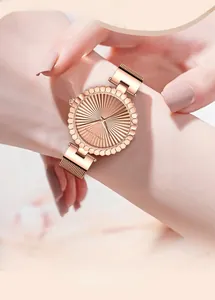 Elegant rose gold women's watch with mesh strap and sunray textured dial on wrist
